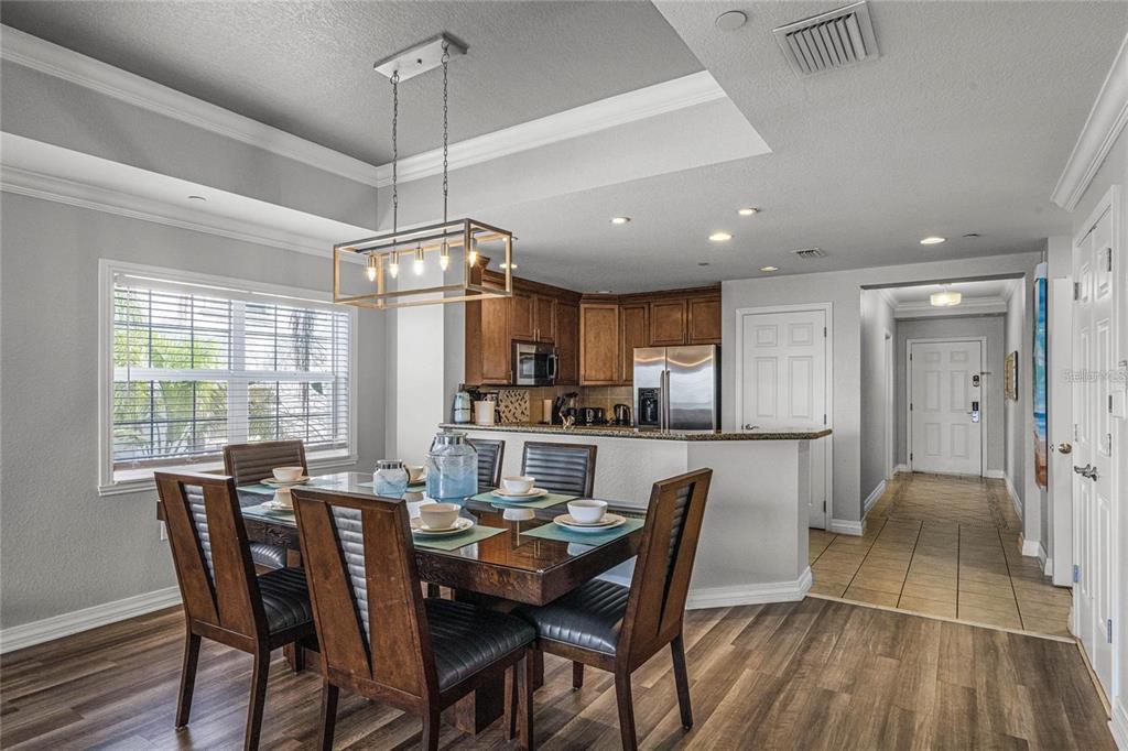 1102 Sunset View Circle, Unit 204 Reunion, FL 34747 - Photo 5 of 26 a dining room with stainless steel appliances kitchen island granite countertop a dining table chairs and white cabinets