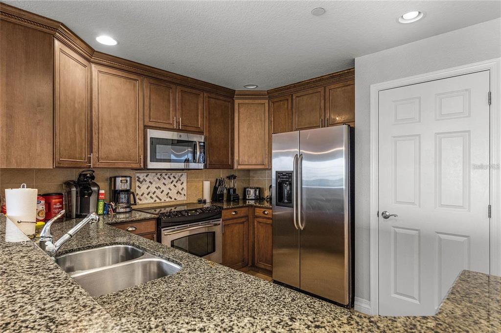 1102 Sunset View Circle, Unit 204 Reunion, FL 34747 - Photo 6 of 26 a kitchen with granite countertop a refrigerator sink and microwave