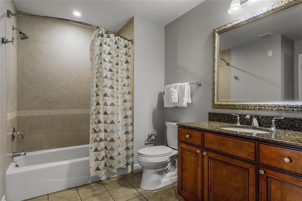 1102 Sunset View Circle, Unit 204 Reunion, FL 34747 - Photo 10 of 26 a bathroom with a bathtub sink mirror toilet and a shower