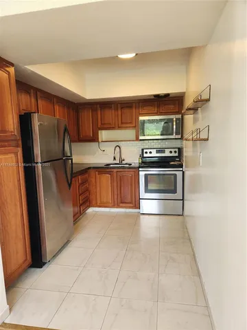 a kitchen with stainless steel appliances granite countertop a refrigerator and a sink