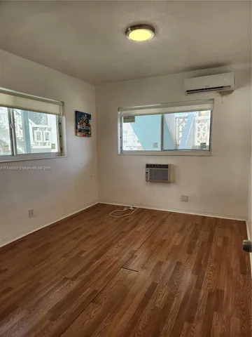 a view of a hallway with wooden floor and a window