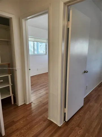 an empty room with wooden floor and closet
