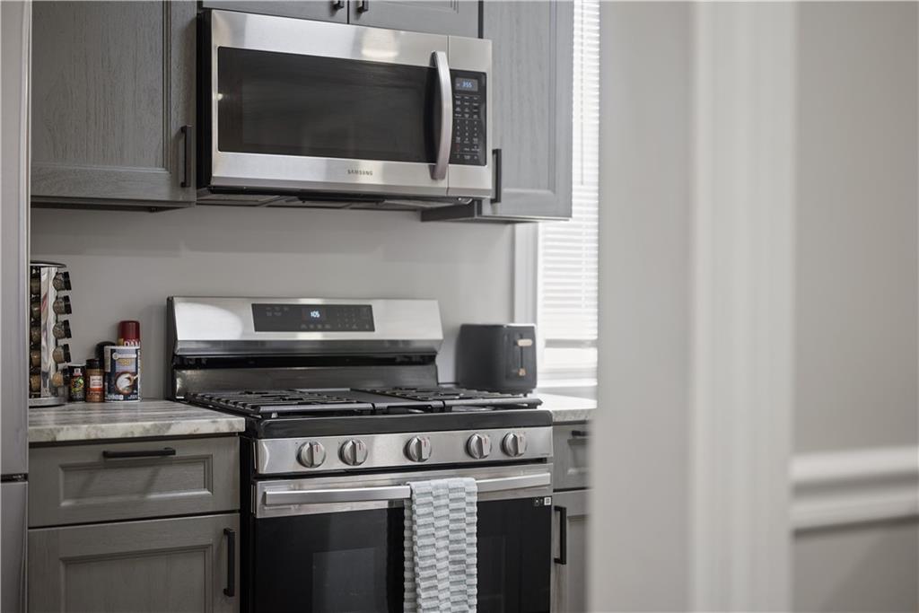 144 Bigham Street Pittsburgh, PA 15211 - Photo 18 of 45 a kitchen with stainless steel appliances a stove a microwave and cabinets