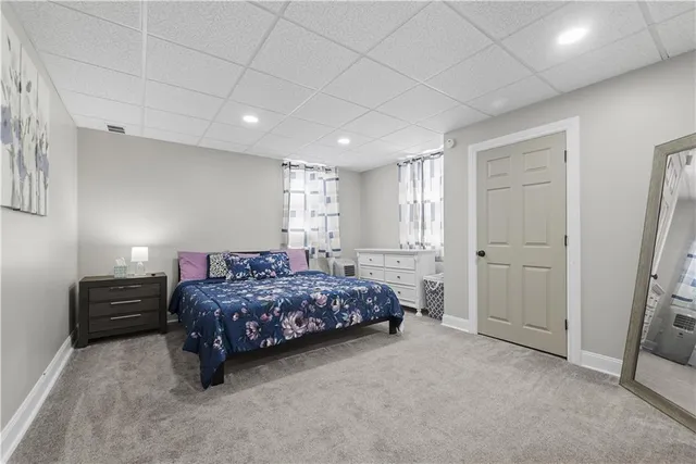 a spacious bedroom with a bed and a flat screen tv