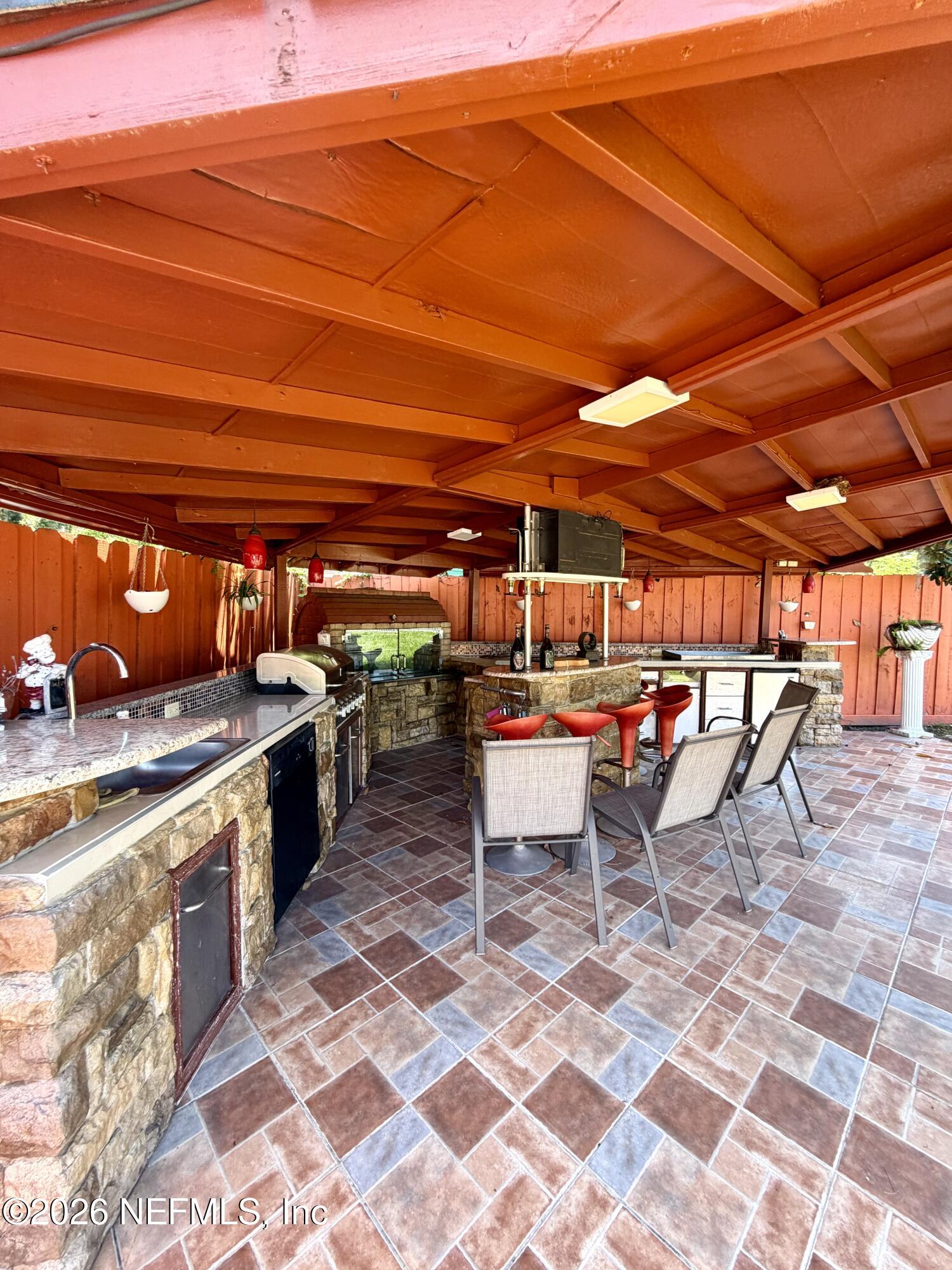 4127 Springwood Road Jacksonville, FL 32207 - Photo 44 of 63 a view of a patio with table and chairs with wooden floor