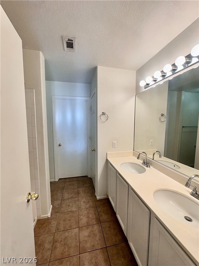 2053 Turquoise Ridge Street, Unit 202 Las Vegas, NV 89117 - Photo 13 of 18 A long vanity with dual sinks sits on tile flooring in this bathroom.