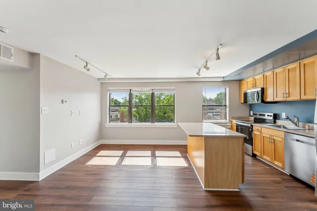 a open kitchen with wooden floors and white cabinets