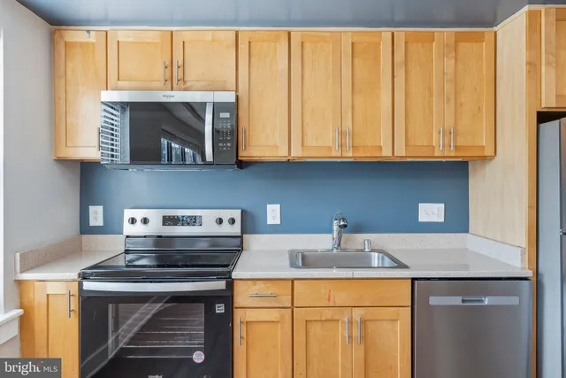 a kitchen with a sink a stove and cabinets