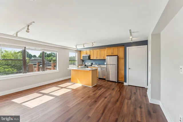 a view of a kitchen with wooden floor and a window