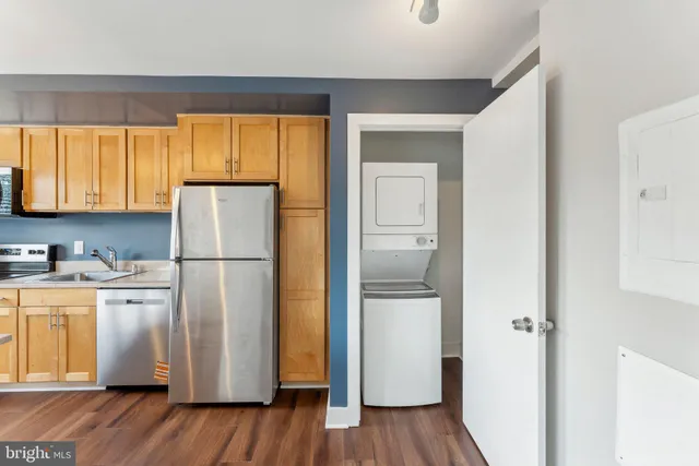 a kitchen with a refrigerator a stove a sink and wooden floor
