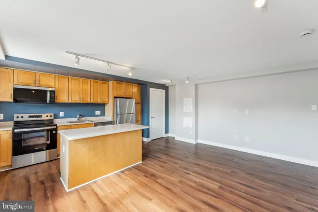a kitchen with stainless steel appliances granite countertop a stove a sink and a refrigerator