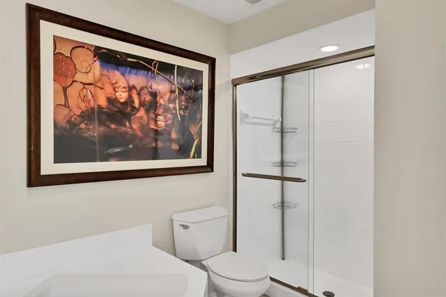 a white toilet sitting next to a shower