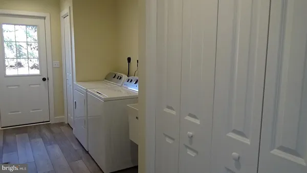 a utility room with wooden floor washer and dryer