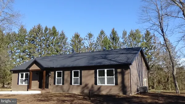 a front view of a house with a yard and trees