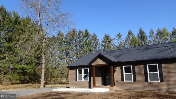 a front view of a house with a yard and trees