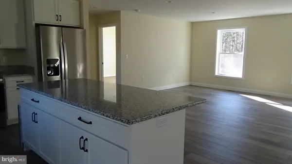 a kitchen with stainless steel appliances granite countertop a refrigerator a sink a stove and island