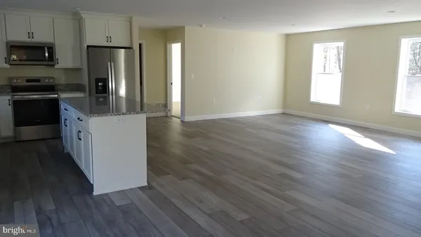 a kitchen with granite countertop wooden floors and stainless steel appliances