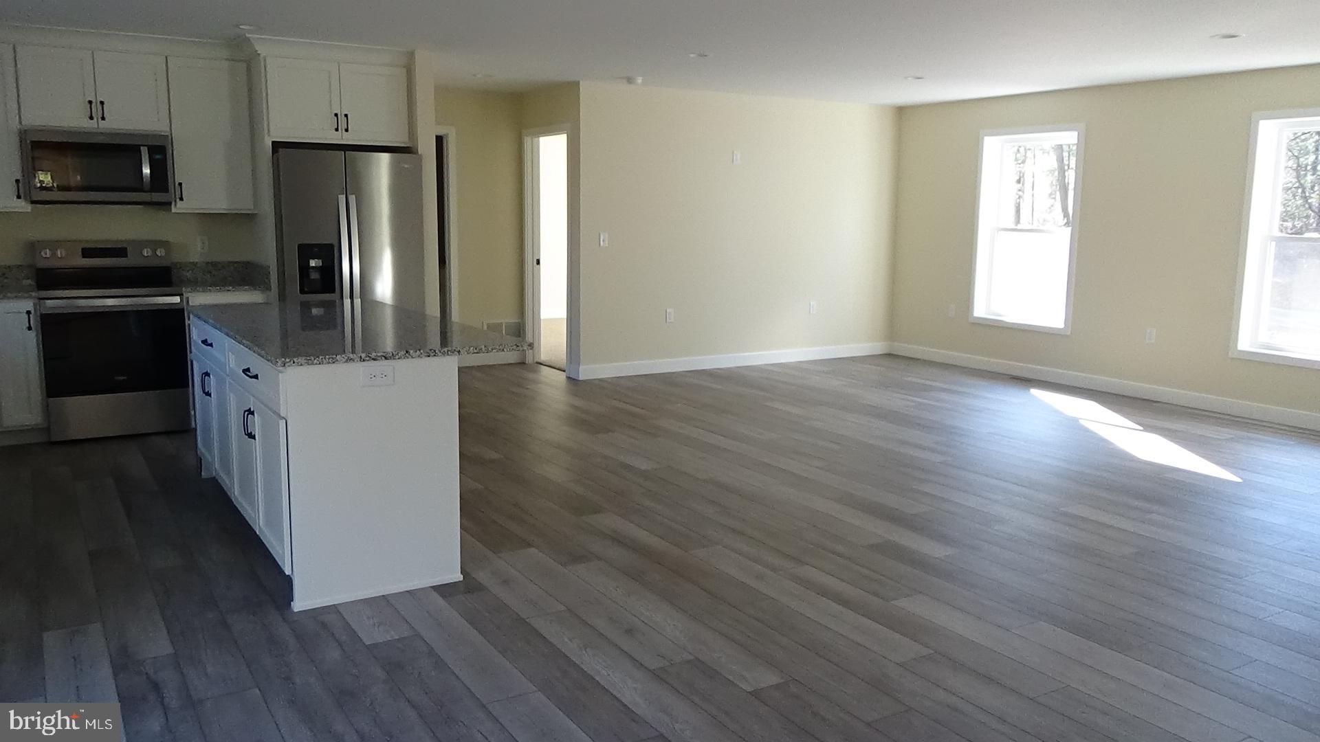 130 Soule Road New Bloomfield, PA 17068 - Photo 7 of 23 a kitchen with granite countertop wooden floors and stainless steel appliances