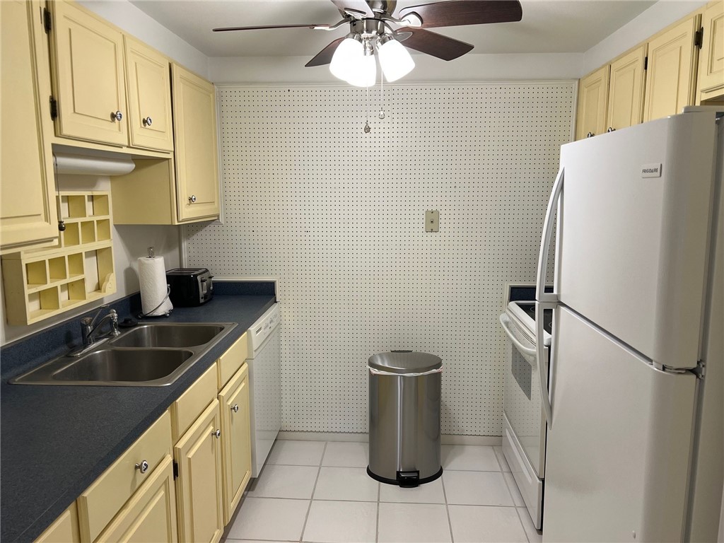 520 South Chaparral Street, Unit 204 Corpus Christi, TX 78401 - Photo 6 of 24 a kitchen with stainless steel appliances granite countertop a refrigerator a sink a stove and white cabinets