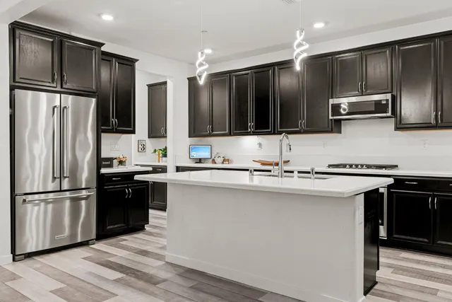 a kitchen with stainless steel appliances granite countertop a sink a stove and a refrigerator
