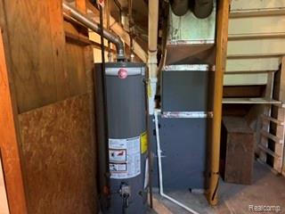 24001 Inkster Road New Boston, MI 48164 - Photo 21 of 23 Water heater and furnace with exposed ductwork and utility piping, framed by wood paneling and unfinished shelving