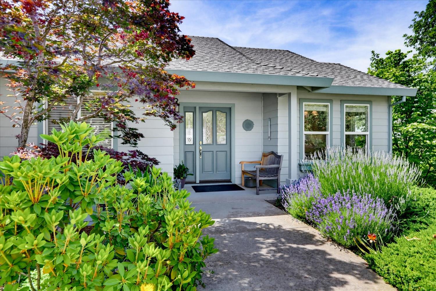 970 Morgan Ranch Drive Grass Valley, CA 95945 - Photo 66 of 76 a view of a house with potted plants and a bench