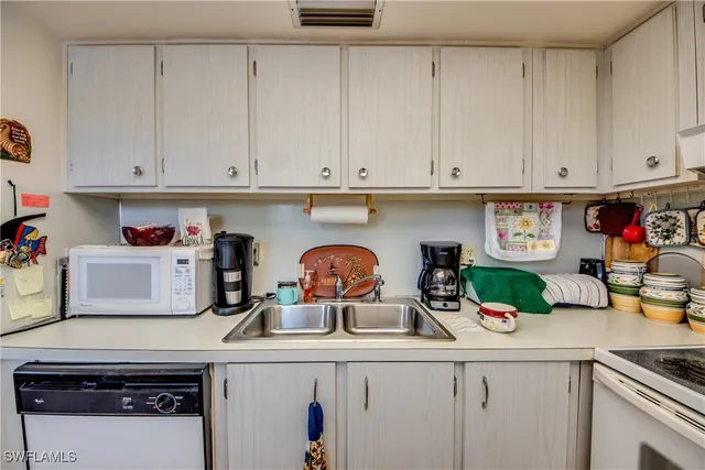 a kitchen with a sink a stove and cabinets