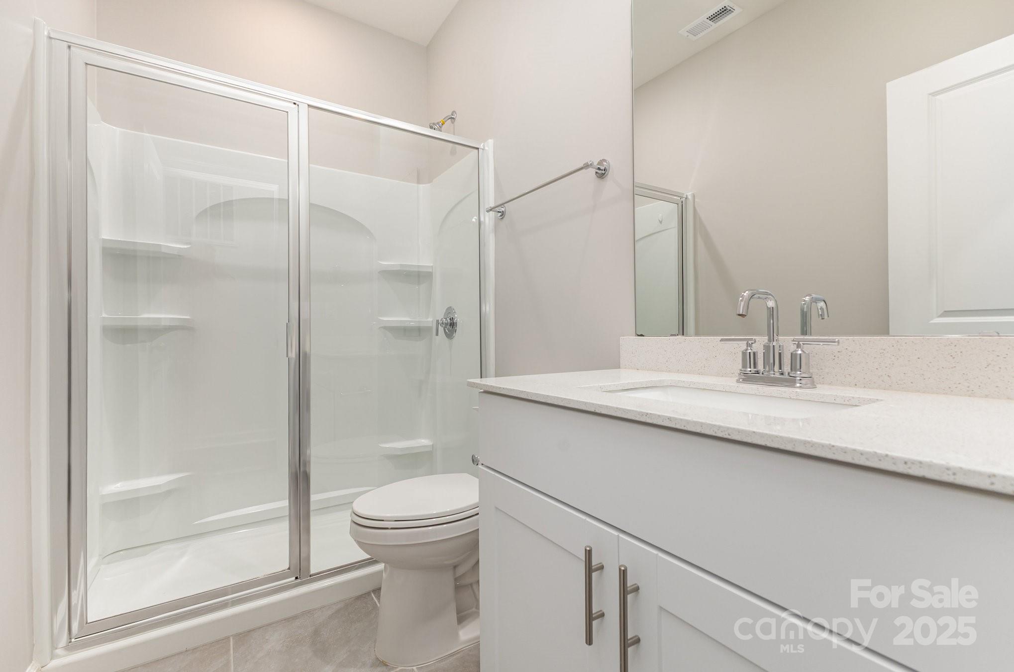 4003 Armstrong Farm Drive Belmont, NC 28012 - Photo 16 of 32 a bathroom with a granite countertop sink a toilet and shower