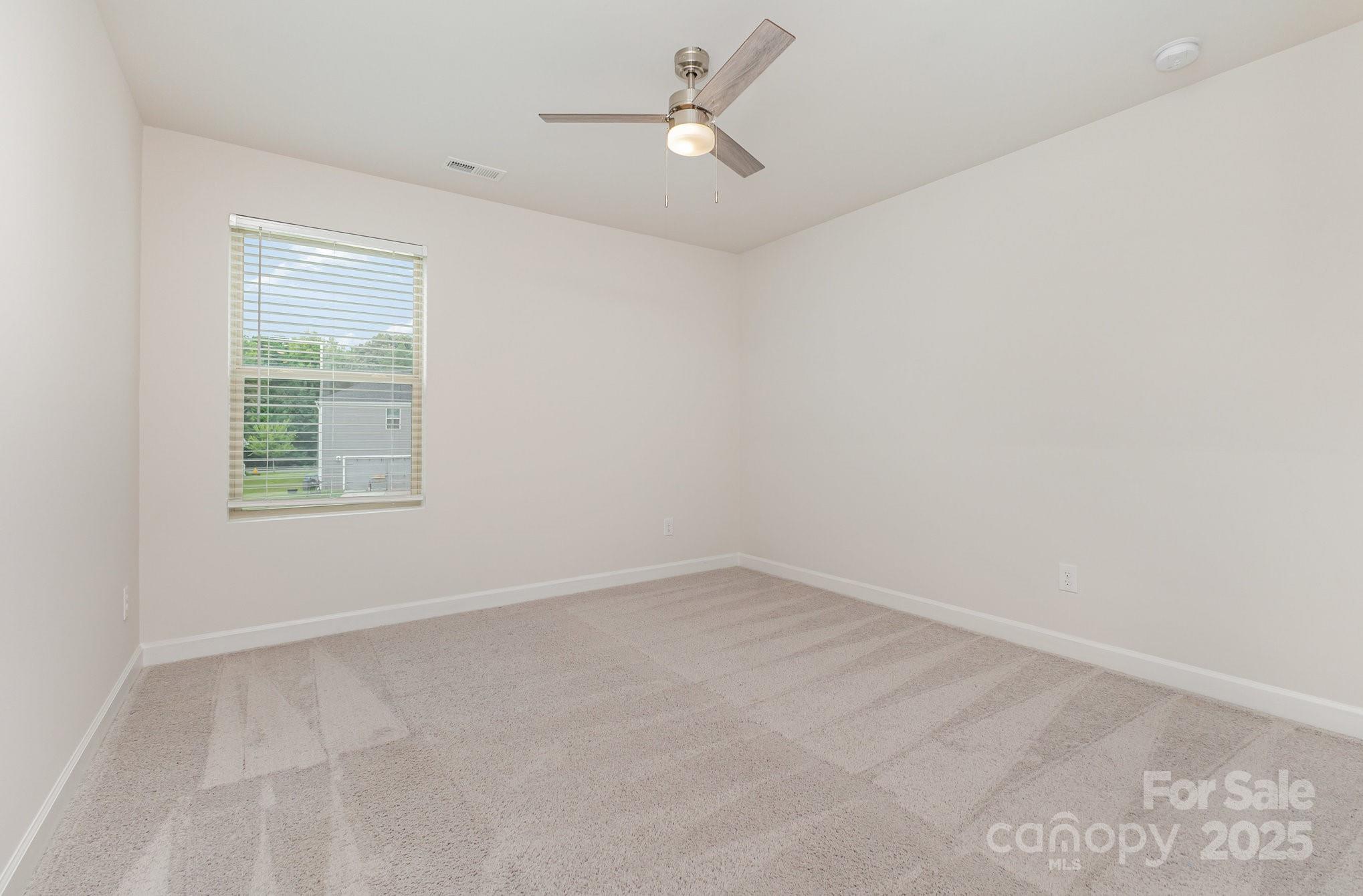 4003 Armstrong Farm Drive Belmont, NC 28012 - Photo 21 of 32 an empty room with a window and ceiling fan