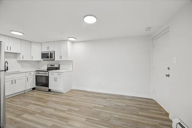 a kitchen with granite countertop white cabinets and stainless steel appliances