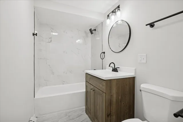 a bathroom with a granite countertop sink a toilet and a mirror