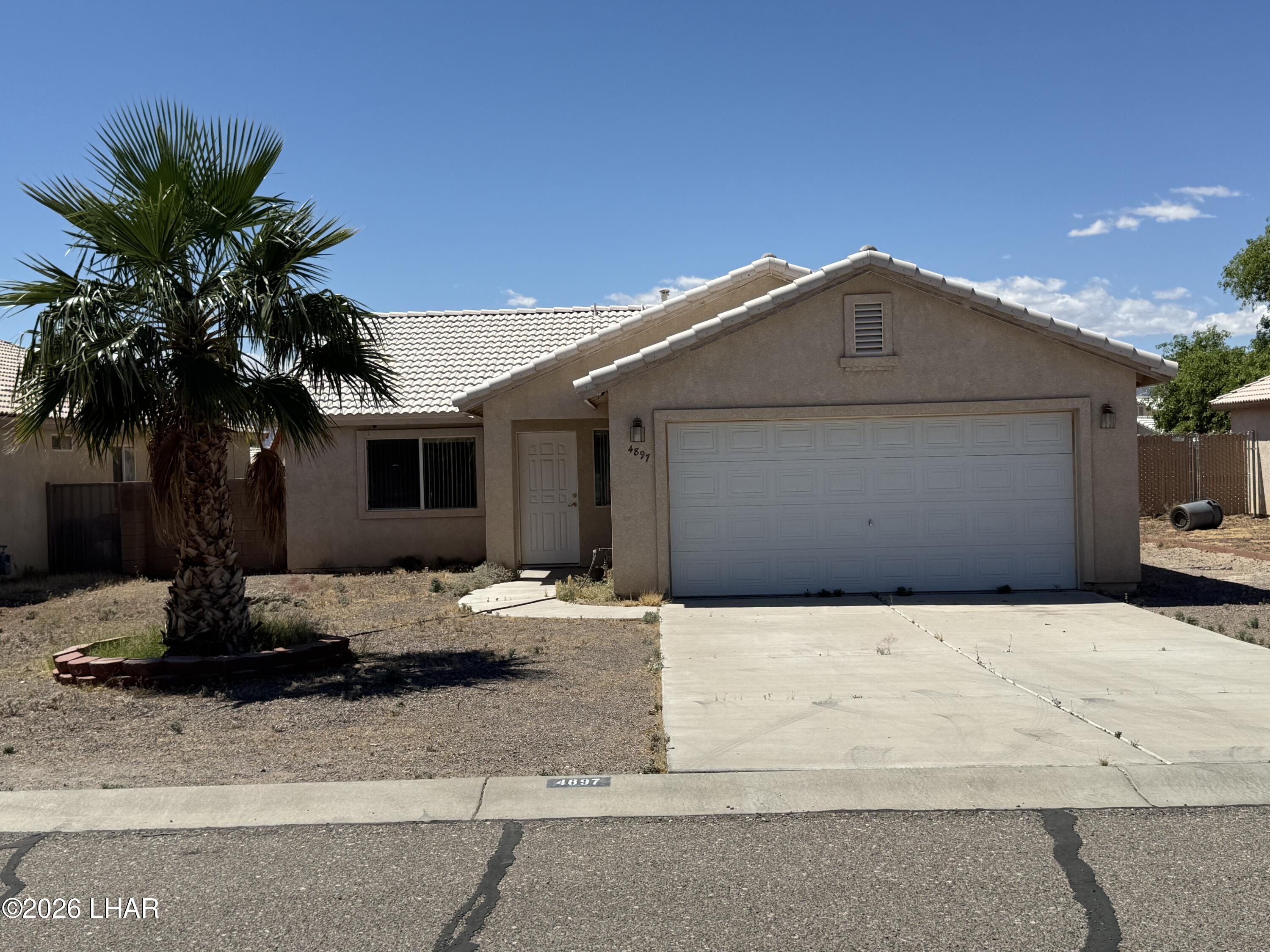 4897 South Rinaldi Drive Fort Mohave, AZ 86426 - Photo 1 of 22 a front view of a house with a yard