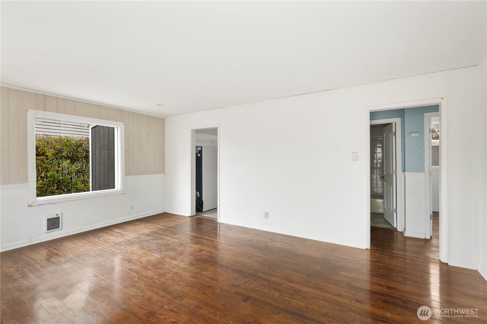 1218 South Ridgewood Avenue Tacoma, WA 98405 - Photo 5 of 24 a view of an empty room with wooden floor and a window