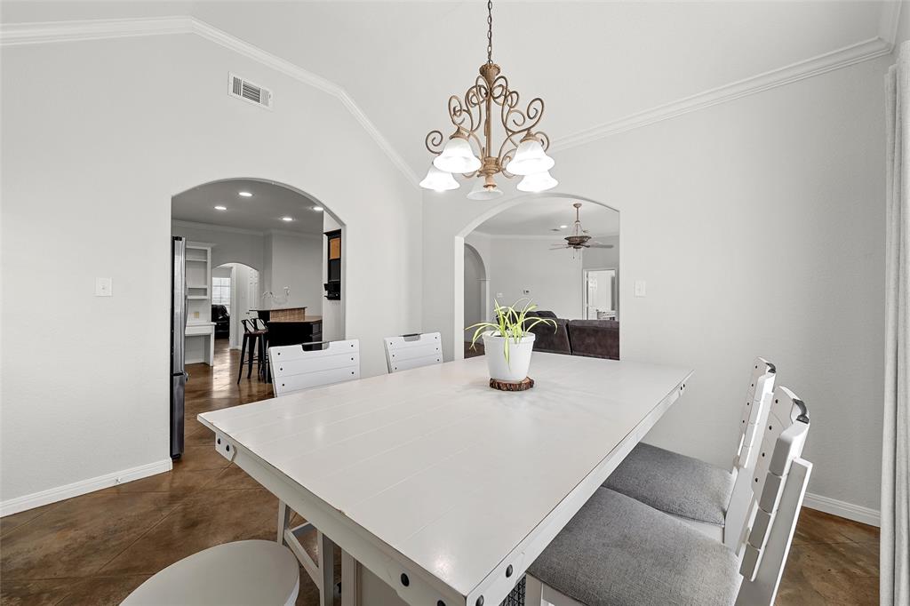 3696 Old Lorena Road Lorena, TX 76655 - Photo 14 of 27 Dining area featuring a decorative chandelier, crown molding, arched doorways, and concrete flooring
