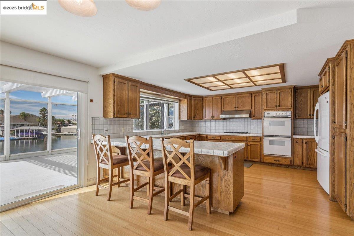5752 Drakes Drive Discovery Bay, CA 94505 - Photo 8 of 32 a kitchen with stainless steel appliances granite countertop a table chairs and a refrigerator
