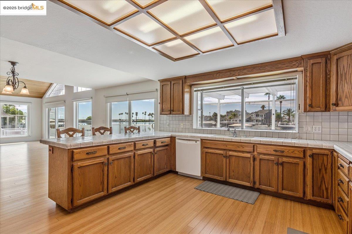 5752 Drakes Drive Discovery Bay, CA 94505 - Photo 9 of 32 a large kitchen with kitchen island granite countertop wooden floors and stainless steel appliances
