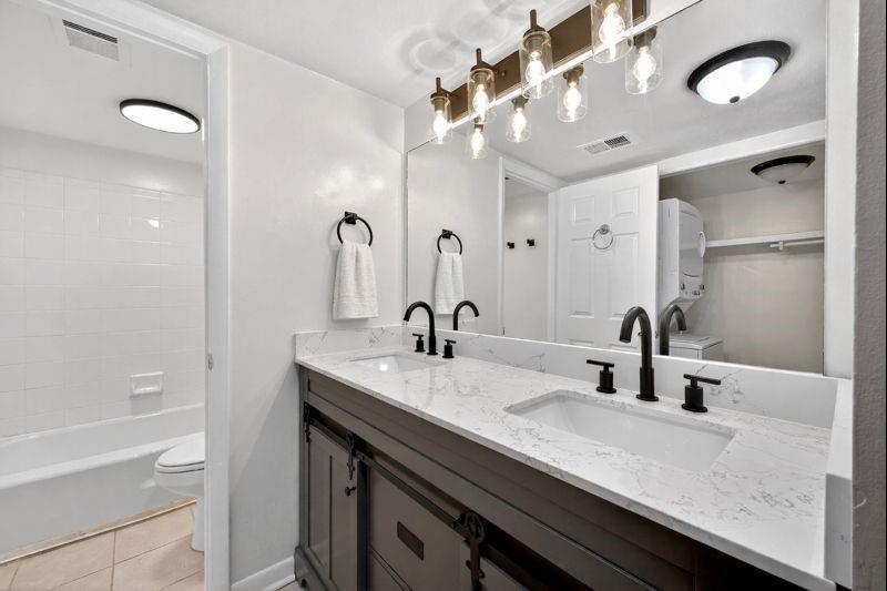 1150 Collier Road Northwest, Unit K9 Atlanta, GA 30318 - Photo 12 of 28 a bathroom with a granite countertop sink a large mirror and shower