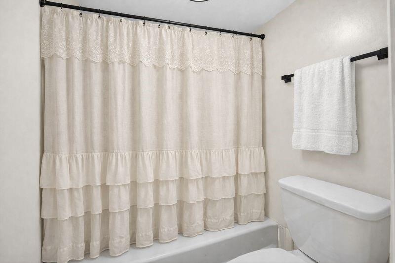 1150 Collier Road Northwest, Unit K9 Atlanta, GA 30318 - Photo 13 of 28 a white toilet sitting next to a shower curtain