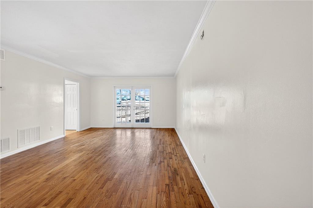 1150 Collier Road Northwest, Unit K9 Atlanta, GA 30318 - Photo 3 of 28 a view of an empty room with wooden floor and a window