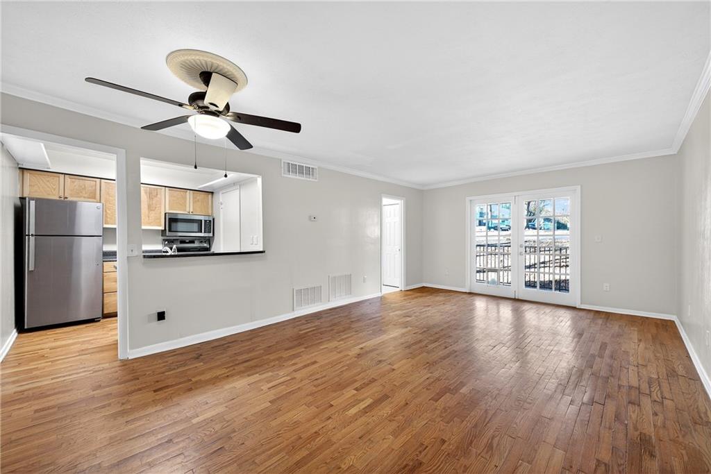 1150 Collier Road Northwest, Unit K9 Atlanta, GA 30318 - Photo 5 of 28 a view of a kitchen with wooden floor a sink a refrigerator and window