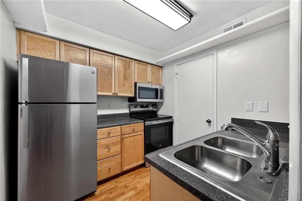 1150 Collier Road Northwest, Unit K9 Atlanta, GA 30318 - Photo 7 of 28 a kitchen with a refrigerator sink and cabinets