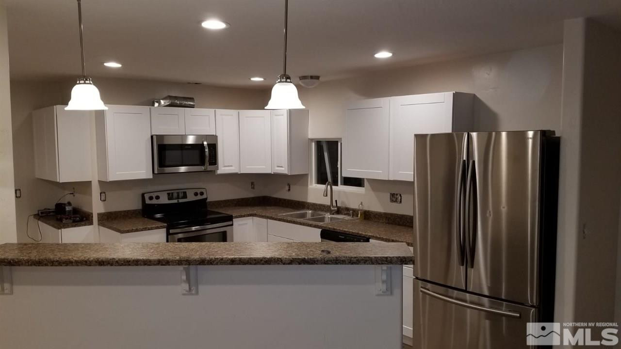 460 Mira Street Reno, NV 89521 - Photo 4 of 5 a kitchen with granite countertop a refrigerator a sink and a stove
