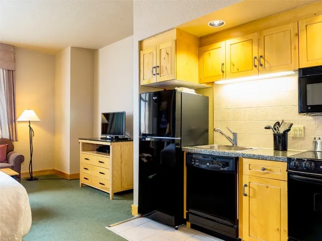 a kitchen with stainless steel appliances kitchen island granite countertop a refrigerator stove and sink