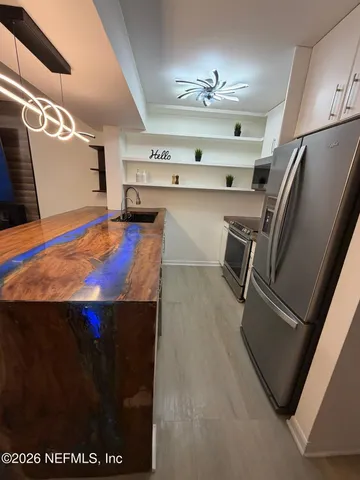 a kitchen with stainless steel appliances a sink stove and cabinets