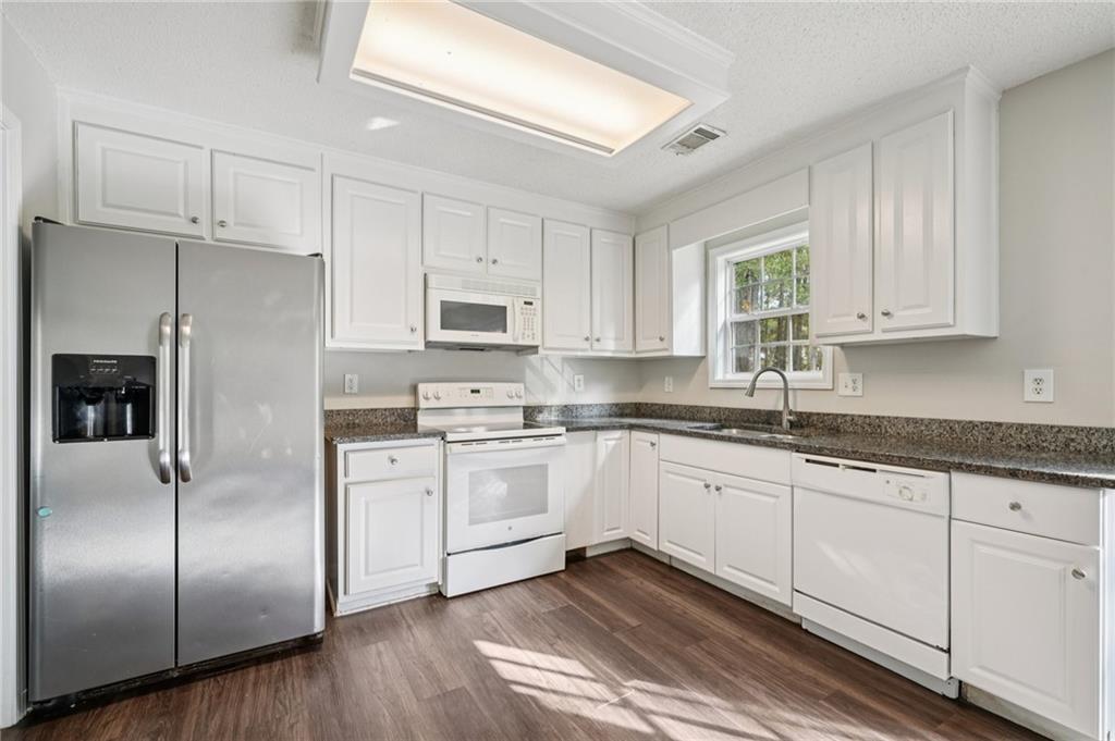 480 Raider Way Bethlehem, GA 30620 - Photo 6 of 30 a kitchen with stainless steel appliances granite countertop a refrigerator sink and white cabinets