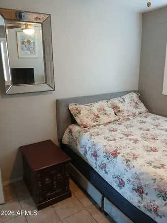 a bed sitting in a bedroom next to a window with tv