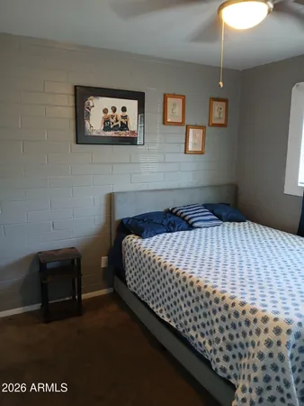 a bedroom with a bed and painting on the wall