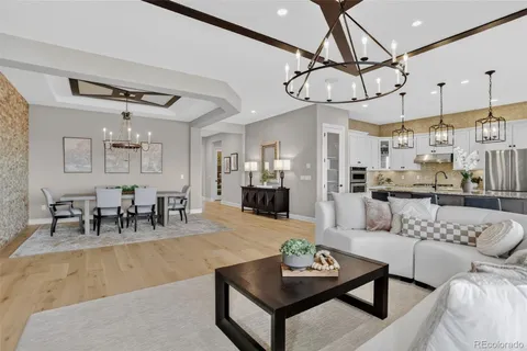 a living room with furniture kitchen view and a chandelier