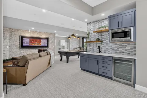 a large white kitchen with stainless steel appliances granite countertop a stove and a sink