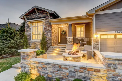 a view of a house with a large window and dining table and chairs in a patio